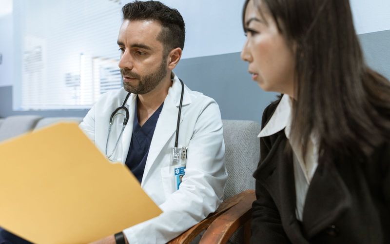 Doctor discusses health records with a patient in a clinical setting
