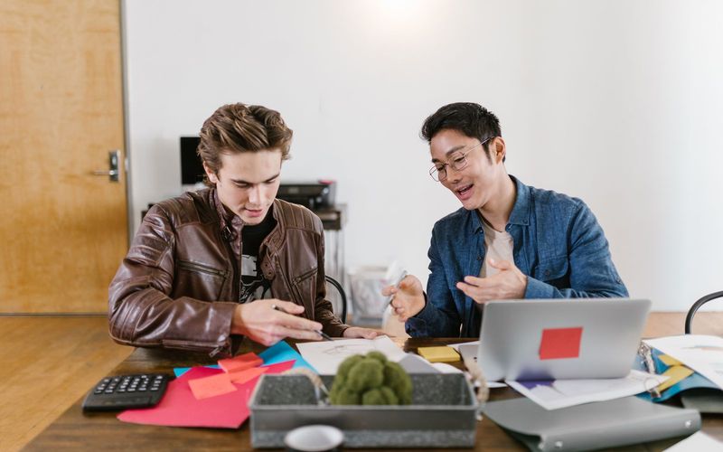 Two business professionals discuss ideas and strategies in an office setting, fostering innovation and teamwork